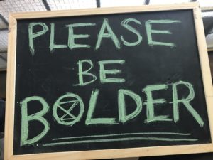 Placard stating Please be bolder